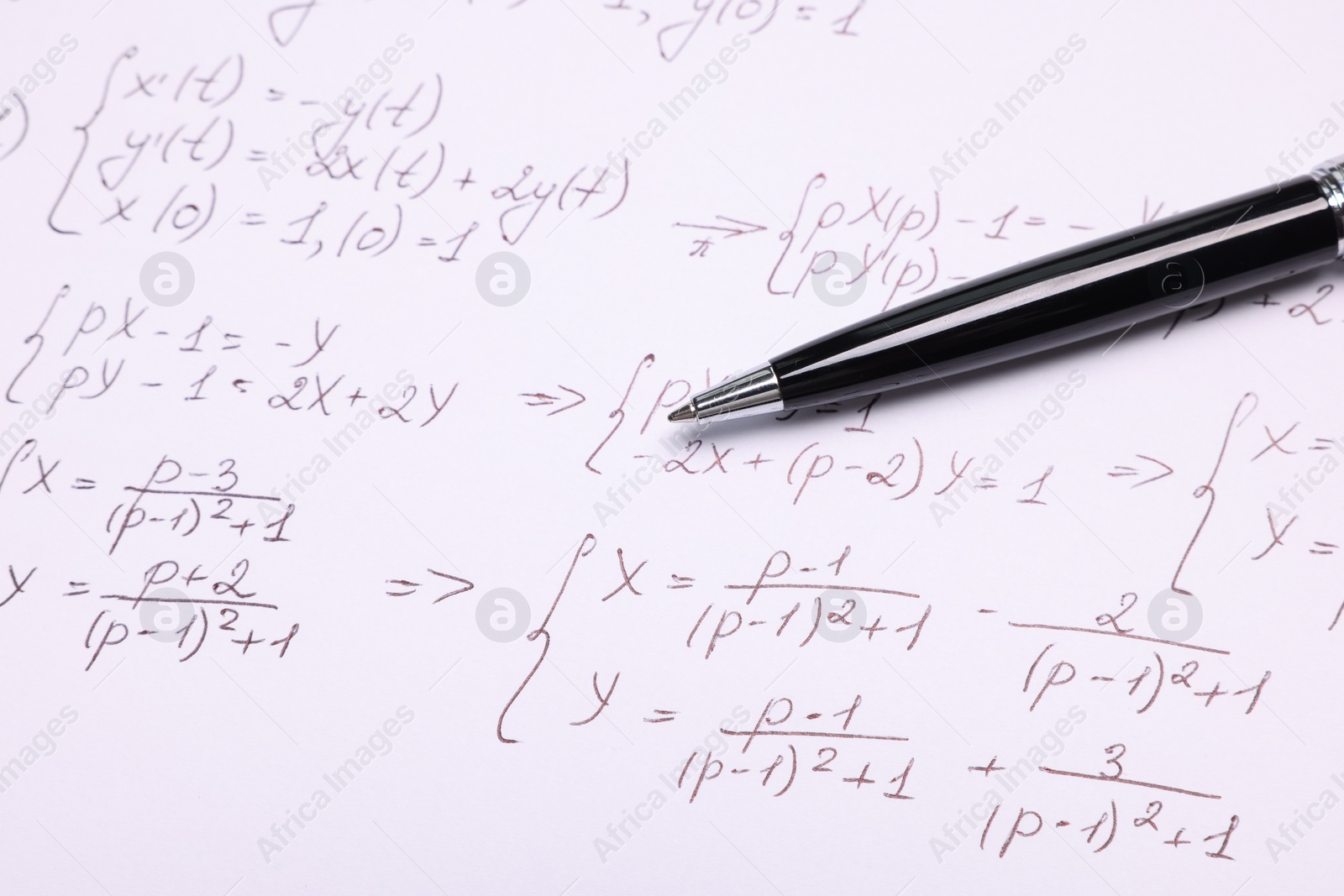 Photo of Sheet of paper with mathematical formulas and pen, closeup