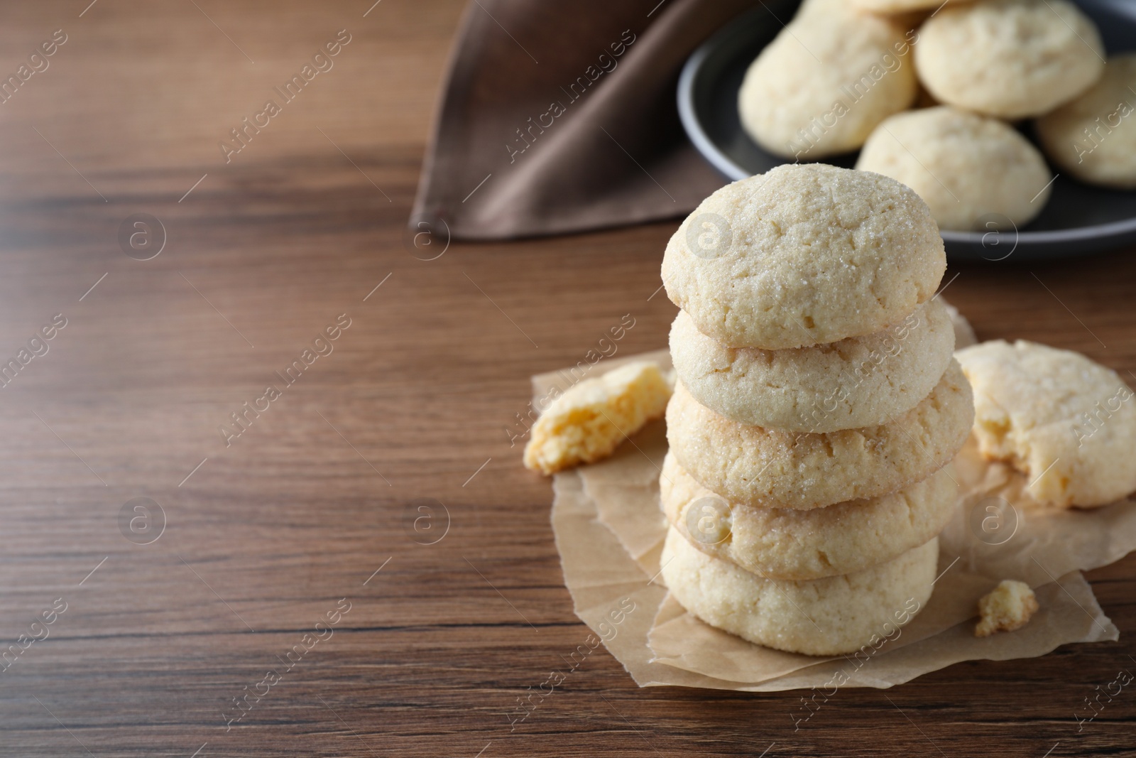 Photo of Stack of tasty sugar cookies on wooden table. Space for text