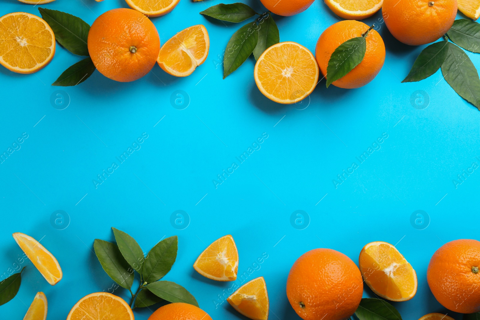 Photo of Delicious oranges on light blue background, flat lay. Space for text