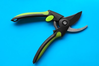 Photo of Secateur on light blue background, top view