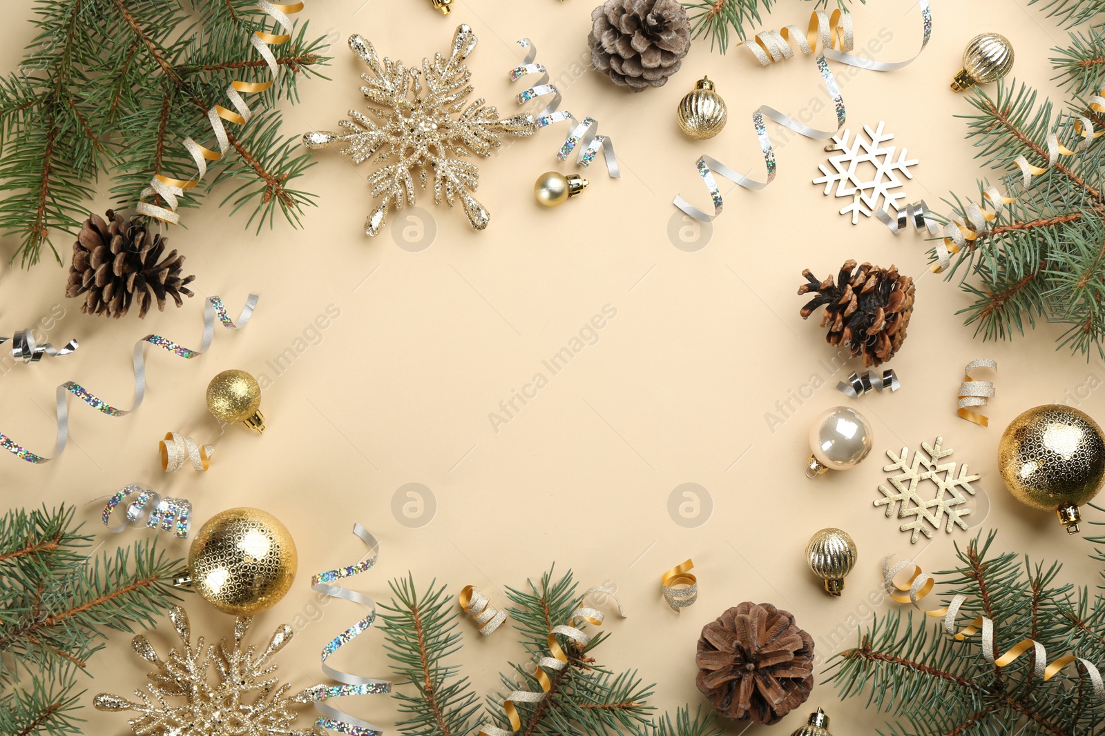 Photo of Frame of serpentine streamers and Christmas decor on beige background, flat lay. Space for text