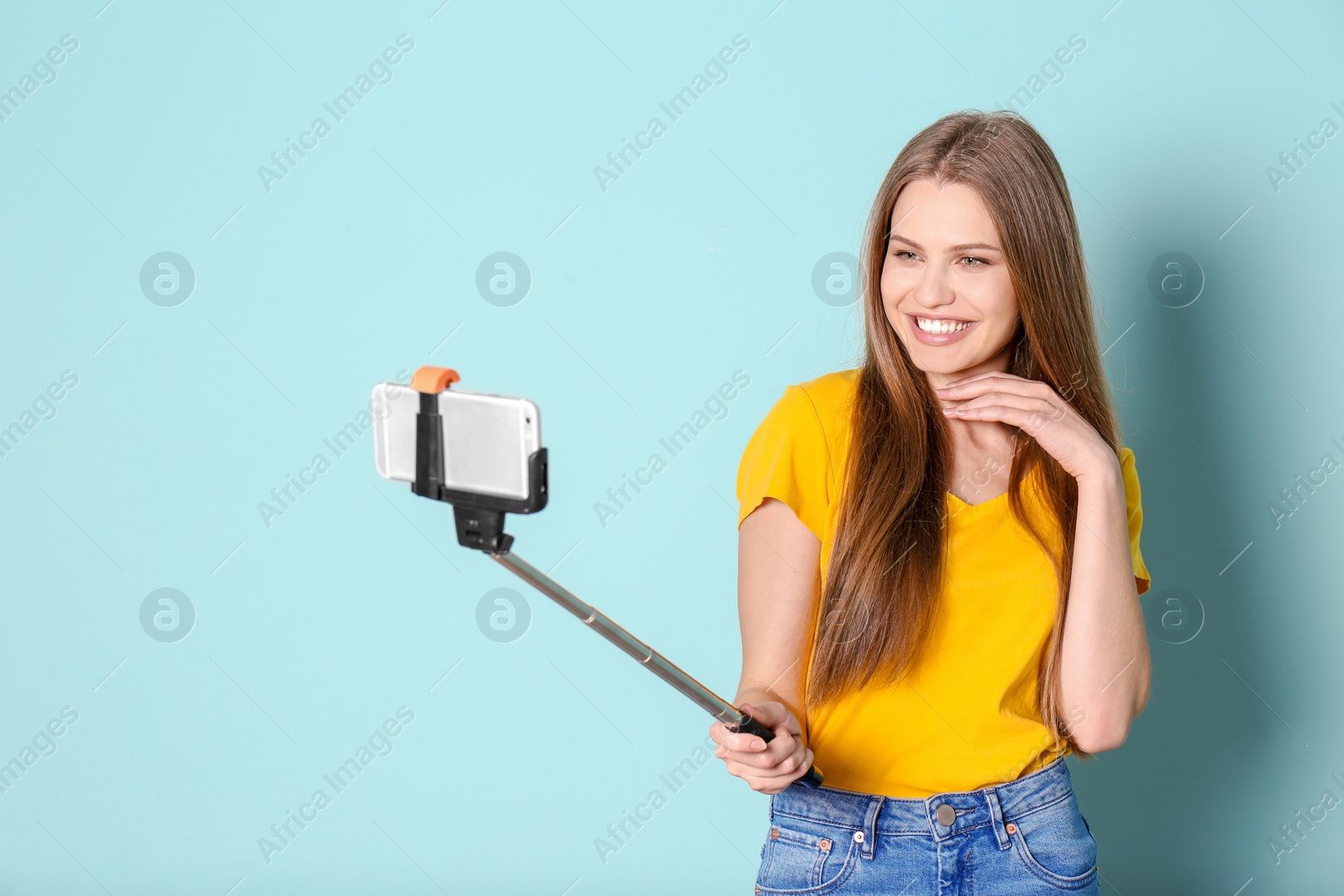 Photo of Young beautiful woman taking selfie against color background