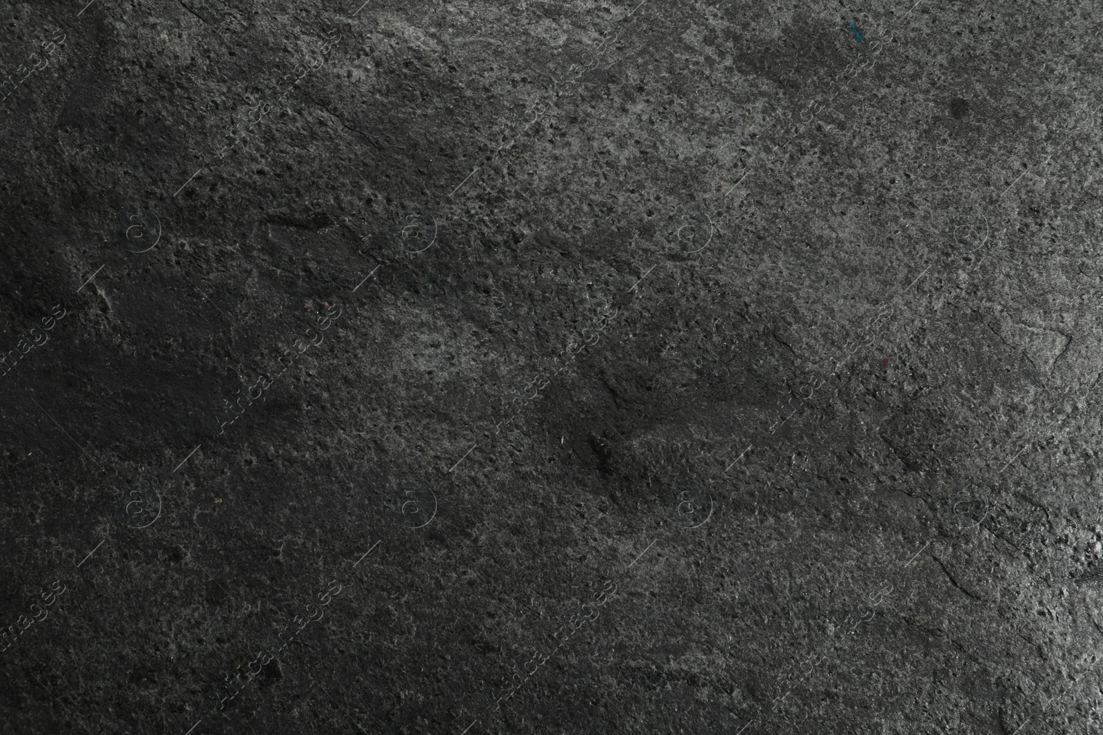 Photo of Texture of dark grey stone surface as background, closeup