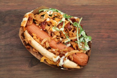 Photo of Fresh delicious hot dog on wooden table, top view