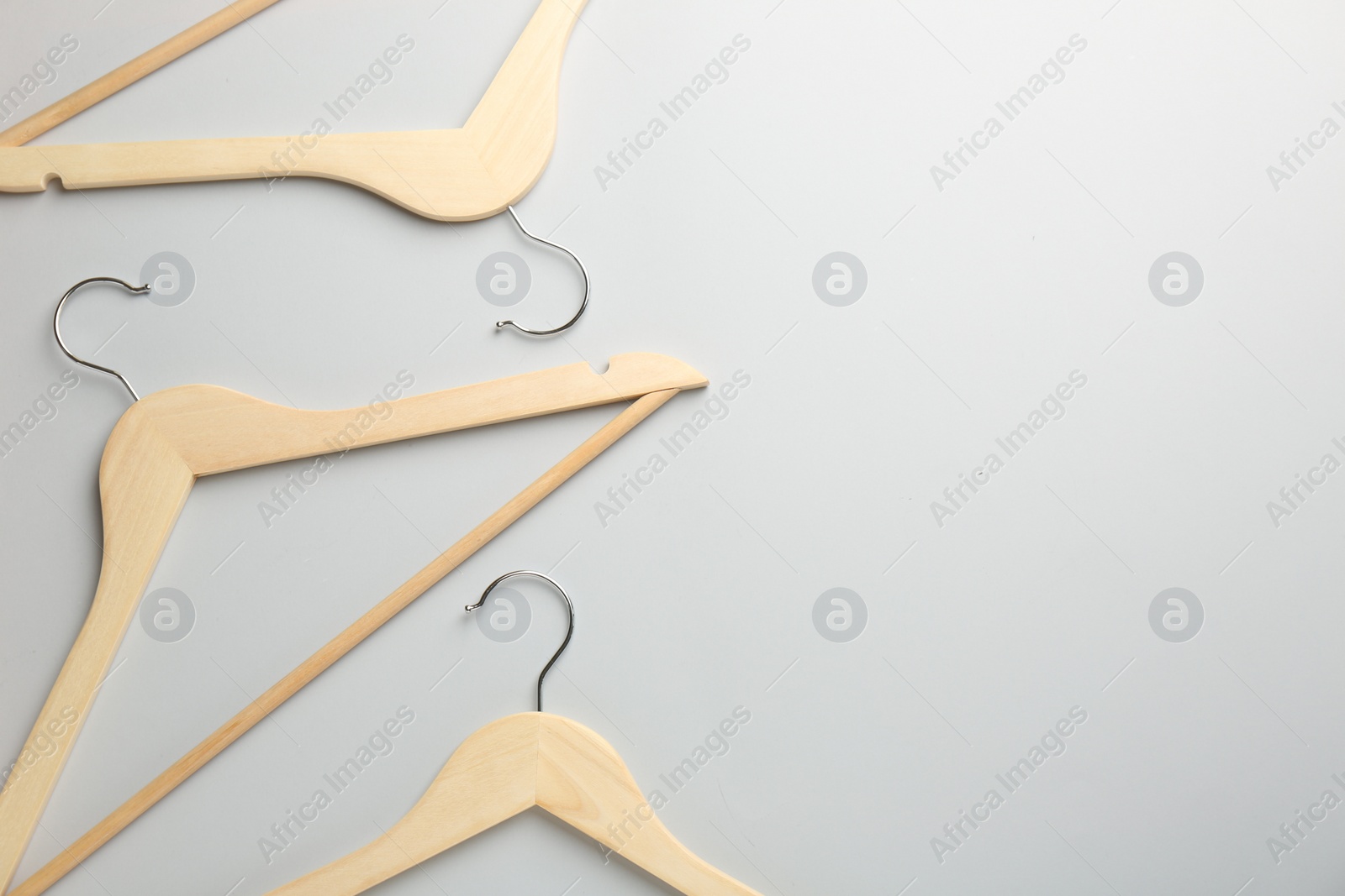 Photo of Wooden hangers on light gray background, flat lay. Space for text