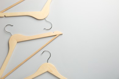 Photo of Wooden hangers on light gray background, flat lay. Space for text