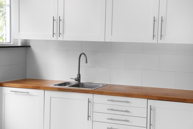 Photo of Stylish kitchen interior with wooden countertop and sink