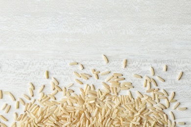 Photo of Brown rice on wooden background, top view with space for text