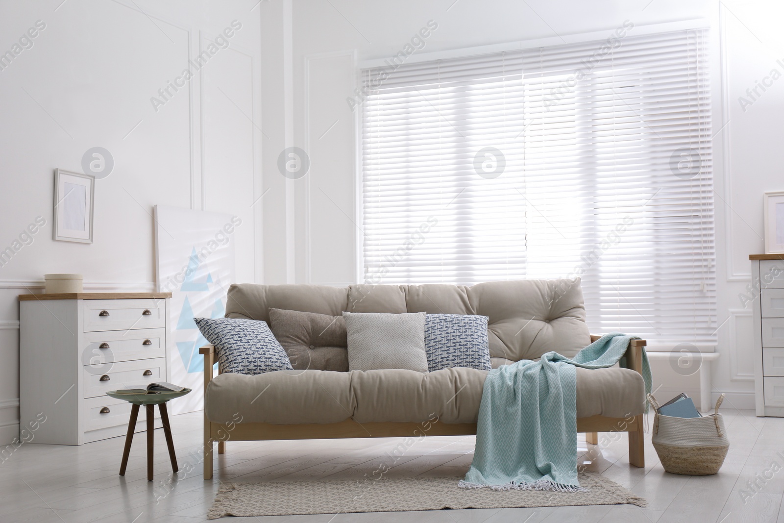 Photo of Stylish living room interior with comfortable sofa and chest of drawers