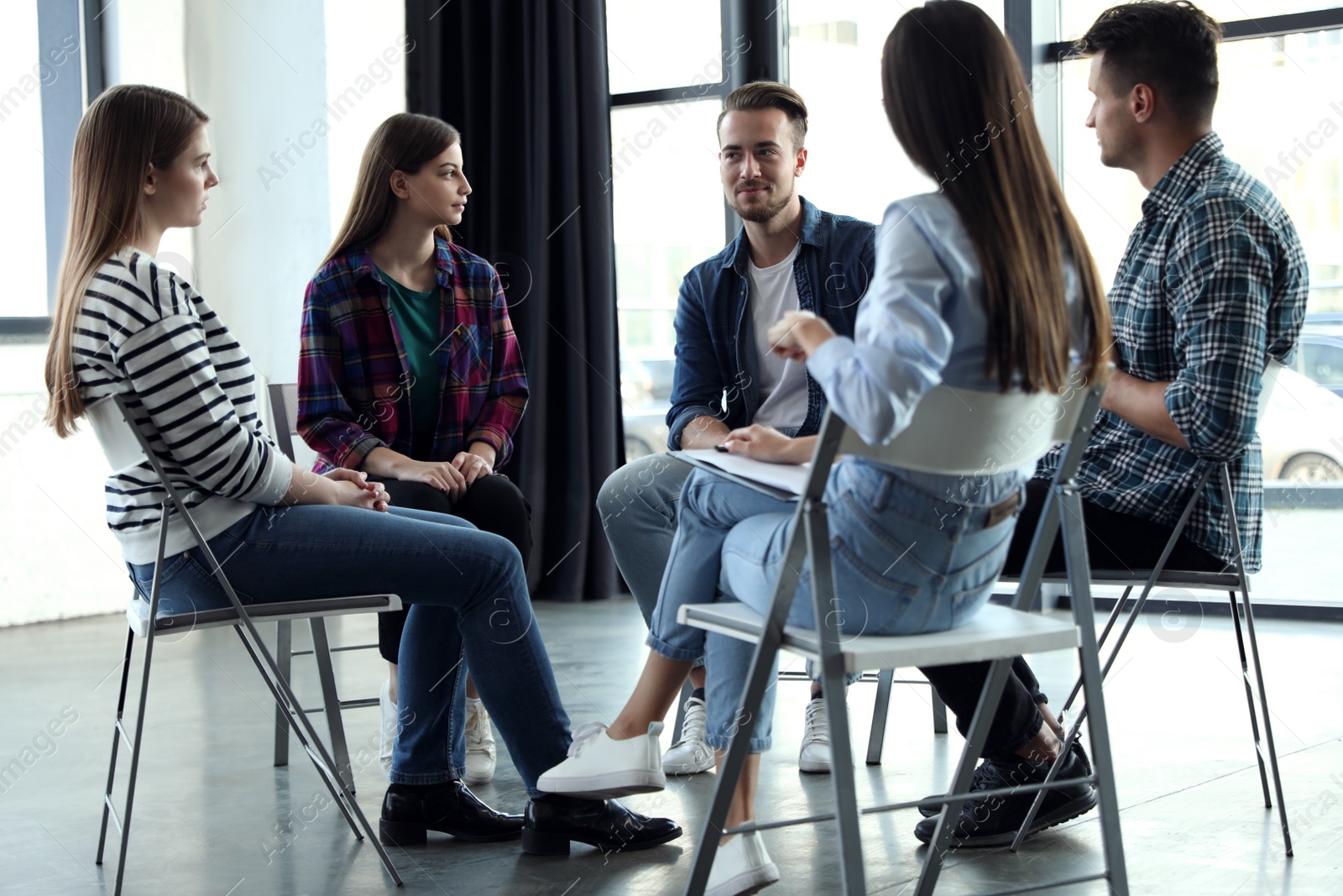 Photo of Psychotherapist working with patients in group therapy session indoors