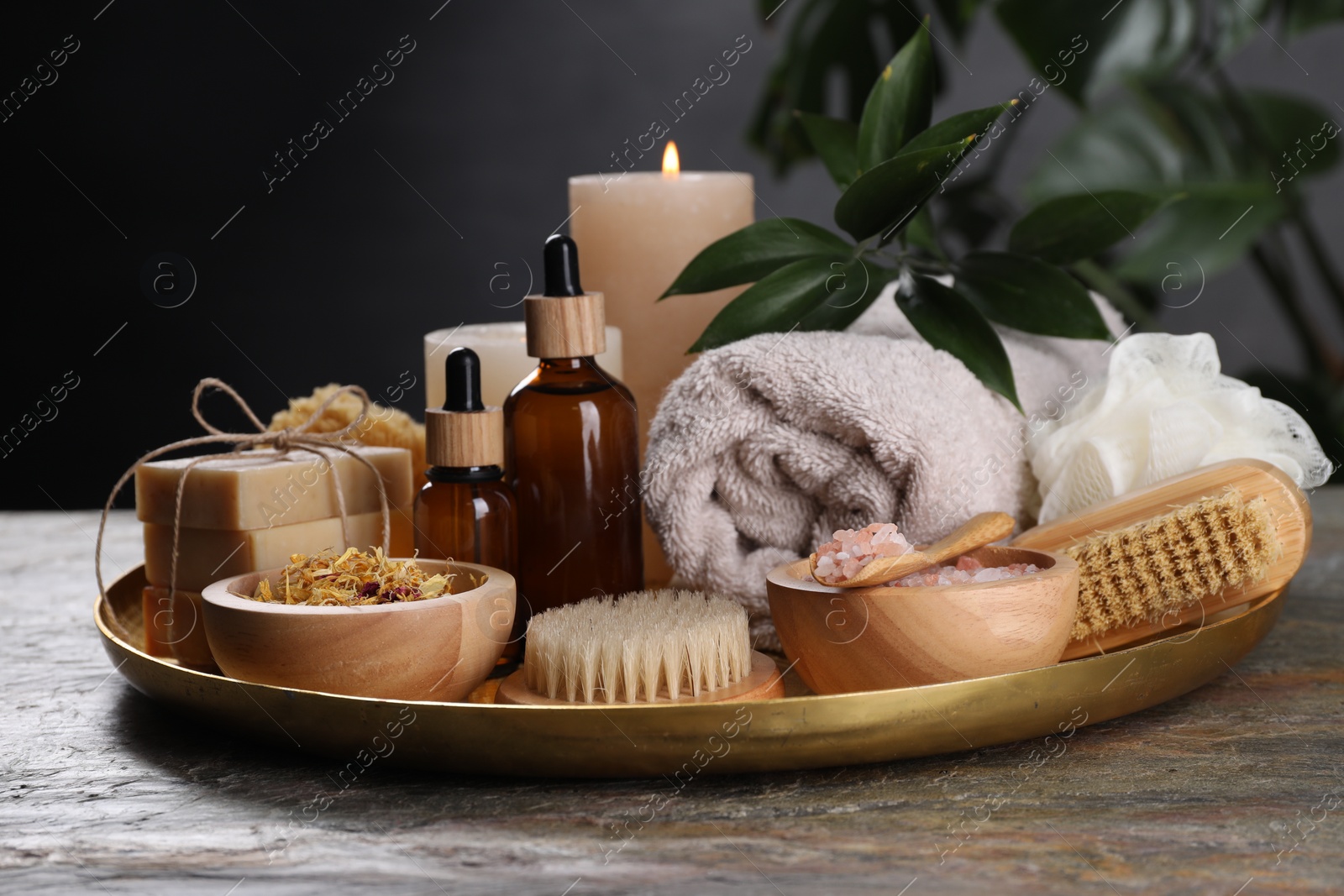 Photo of Spa composition. Brushes, bottles and sea salt on grey textured table