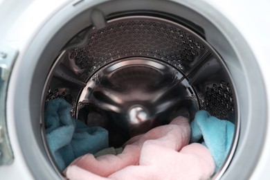 Photo of Modern washing machine drum with laundry, closeup