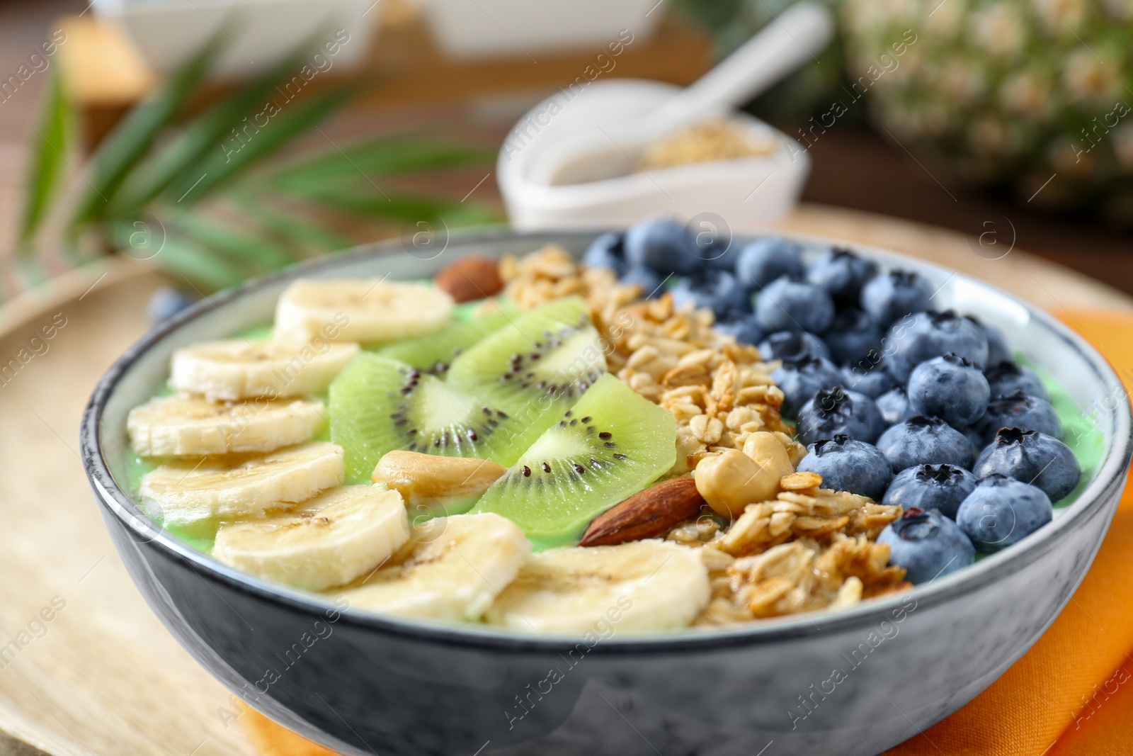 Photo of Tasty smoothie bowl with fresh fruits and oatmeal on table, closeup