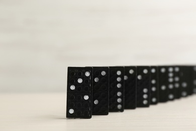 Photo of Black domino tiles with pips on white table