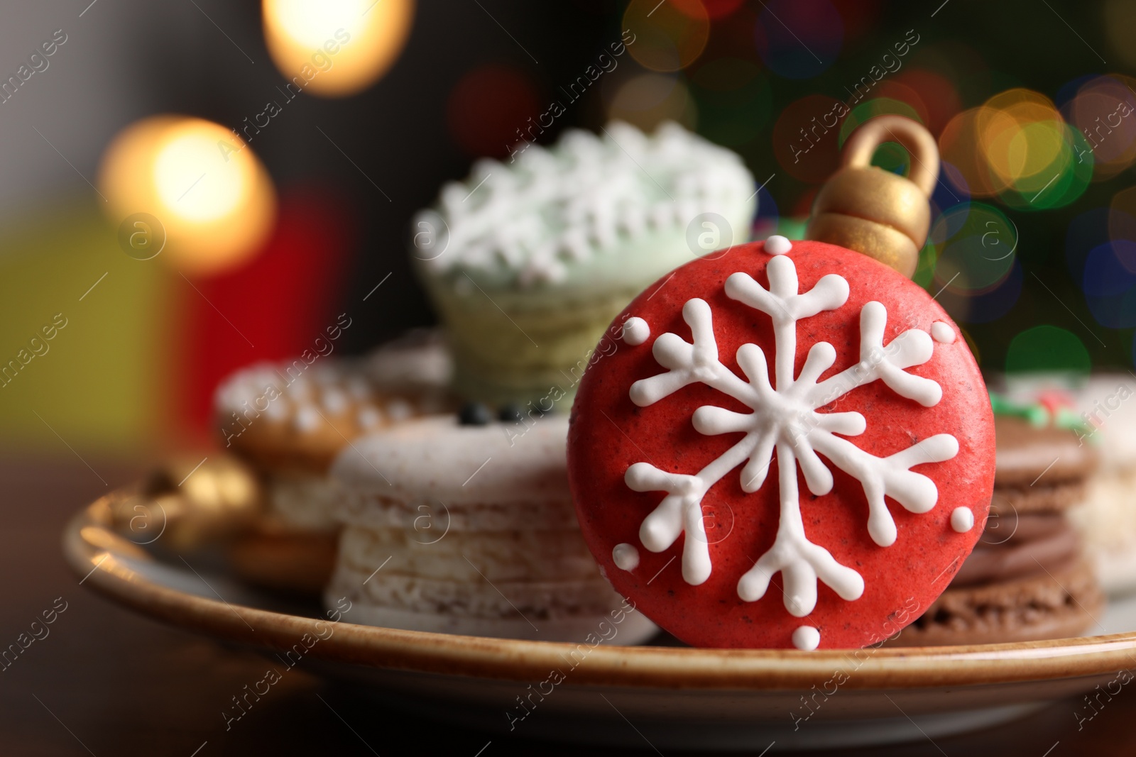 Photo of Beautifully decorated Christmas macarons on wooden table against blurred festive lights, closeup. Space for text