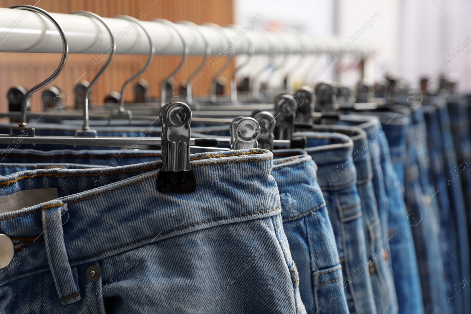 Photo of Rack with different stylish jeans, closeup view