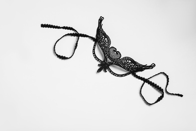 Photo of Black lace mask for sexual role play on white background, top view