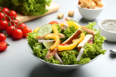 Photo of Delicious fresh chicken salad served on grey table, closeup