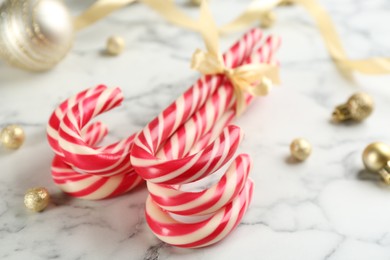 Photo of Bunch of Christmas candy canes on white marble table, closeup