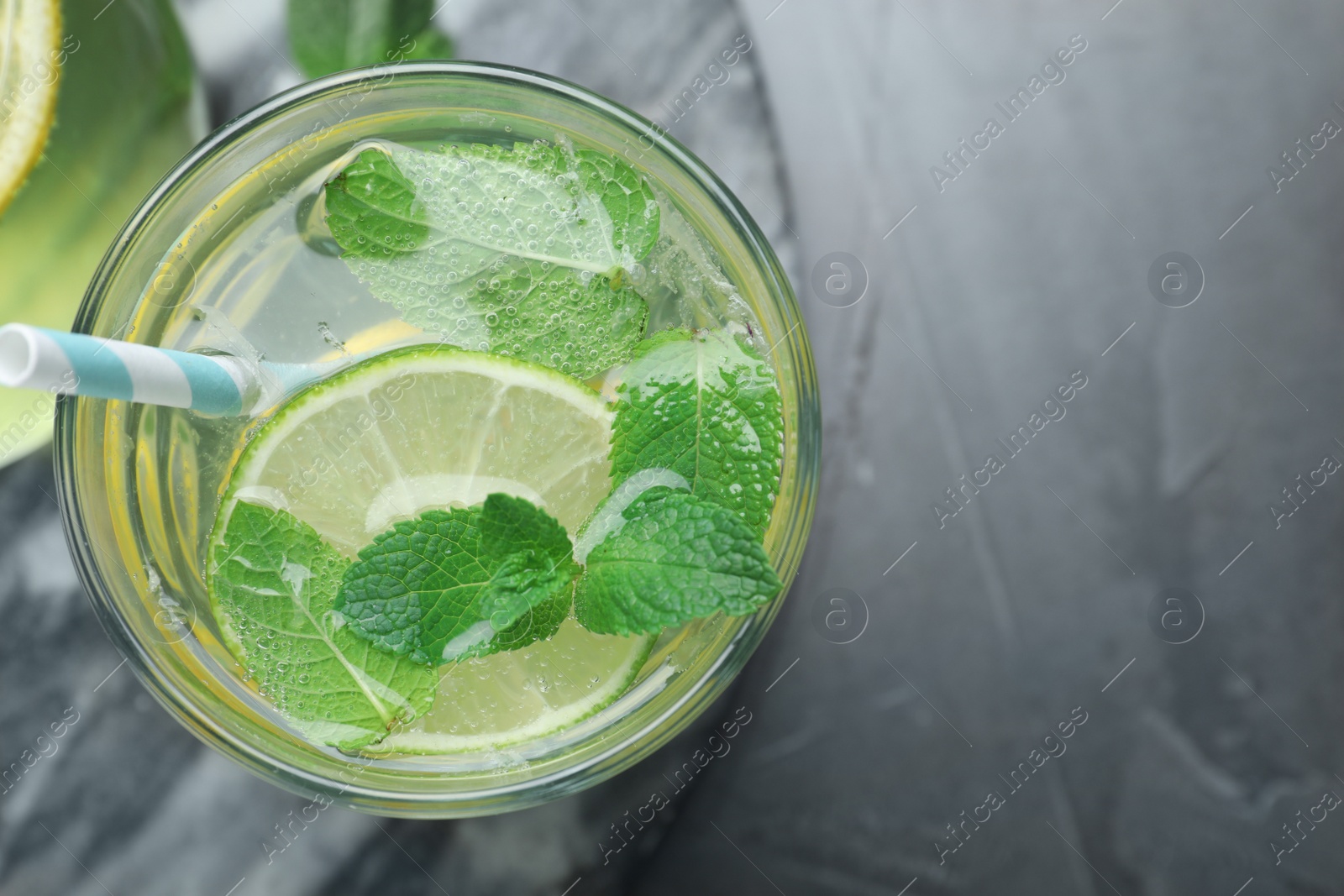 Photo of Delicious lemonade made with soda water on grey table, top view. Space for text