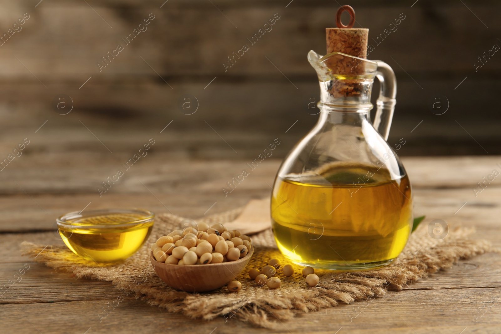 Photo of Composition with soybean oil on wooden table