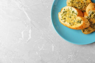 Photo of Slices of toasted bread with garlic, cheese and herbs on grey table, top view. Space for text