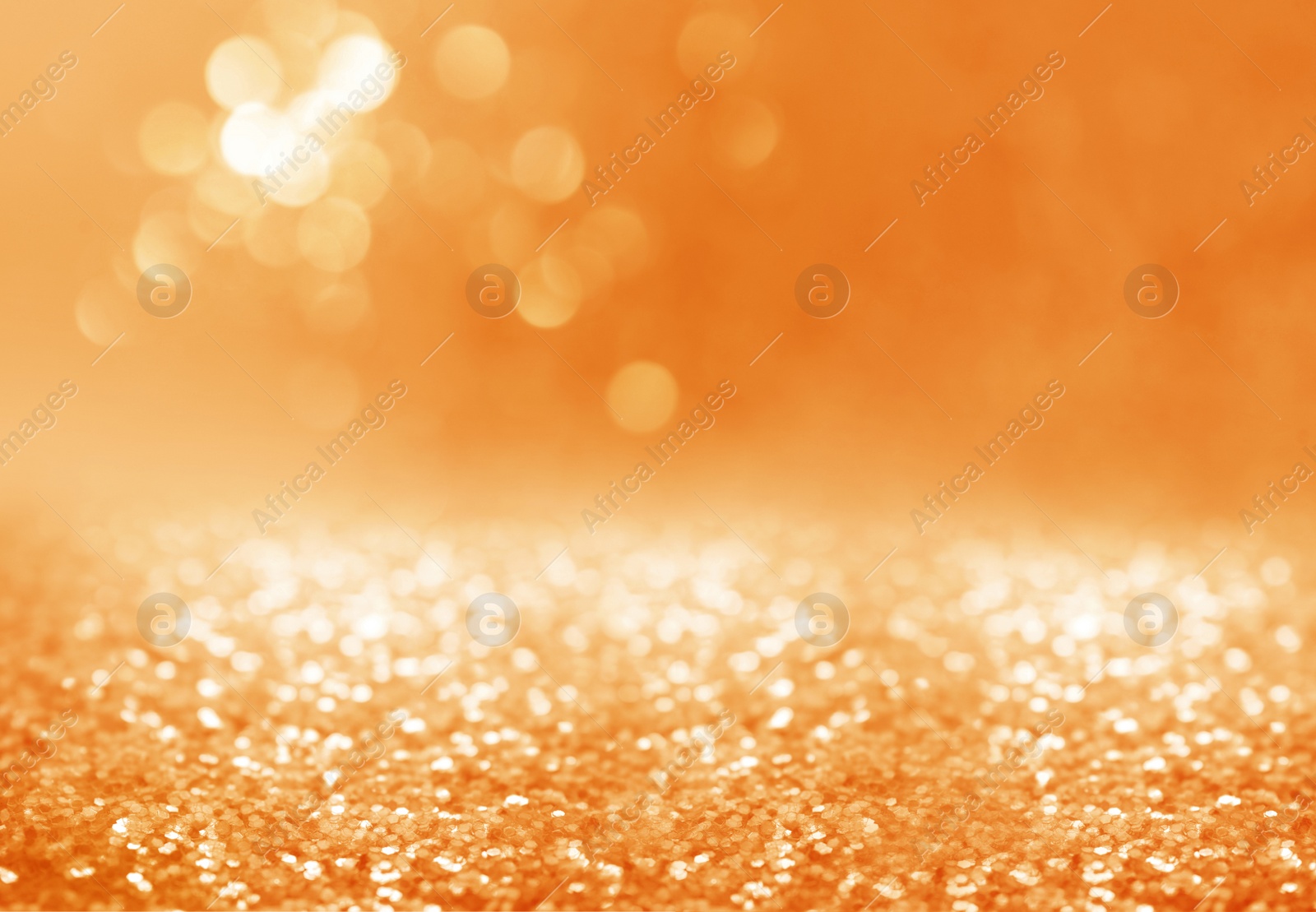 Image of Shiny orange glitter and blurred lights on background. Bokeh effect