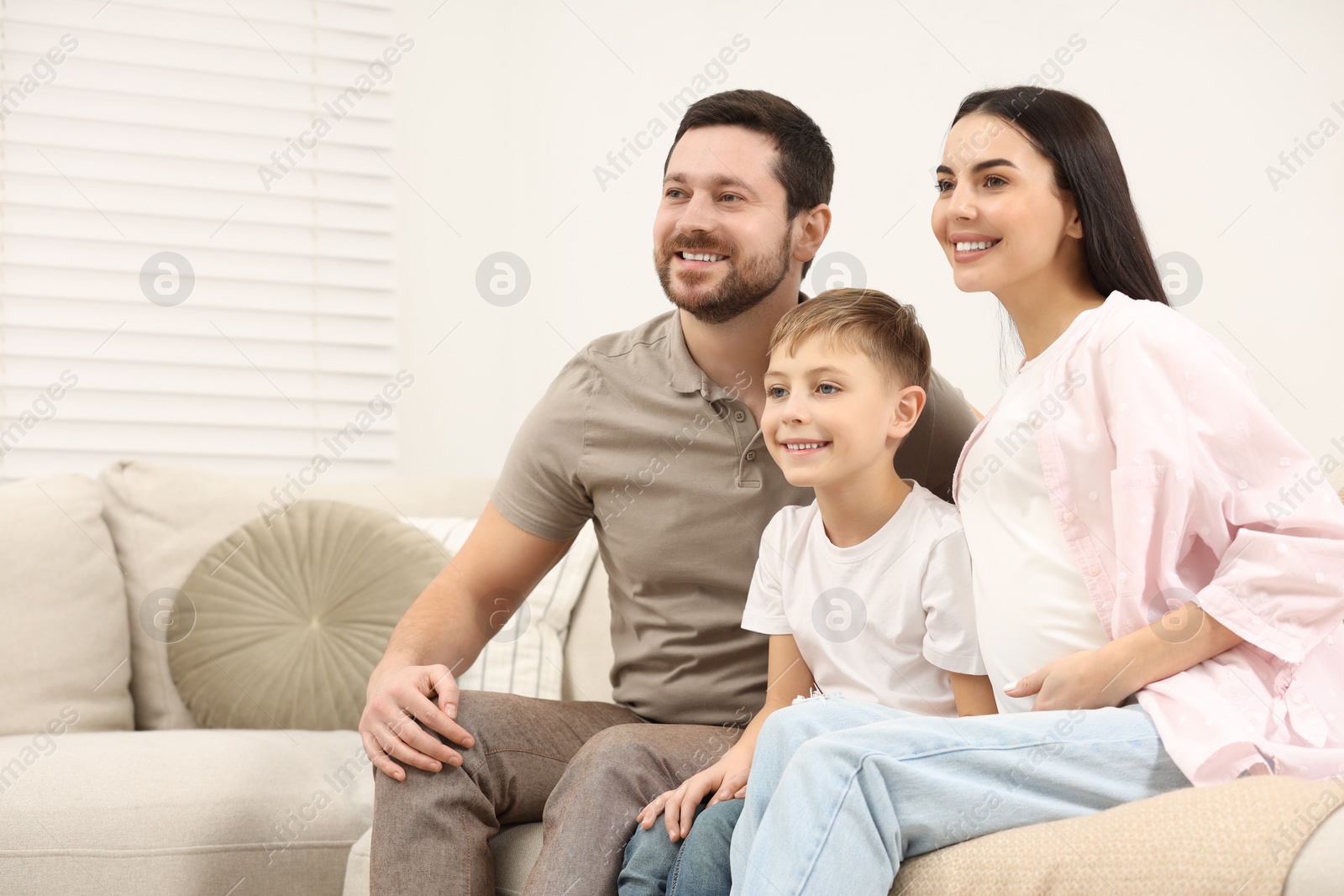 Photo of Happy pregnant woman spending time with her son and husband at home