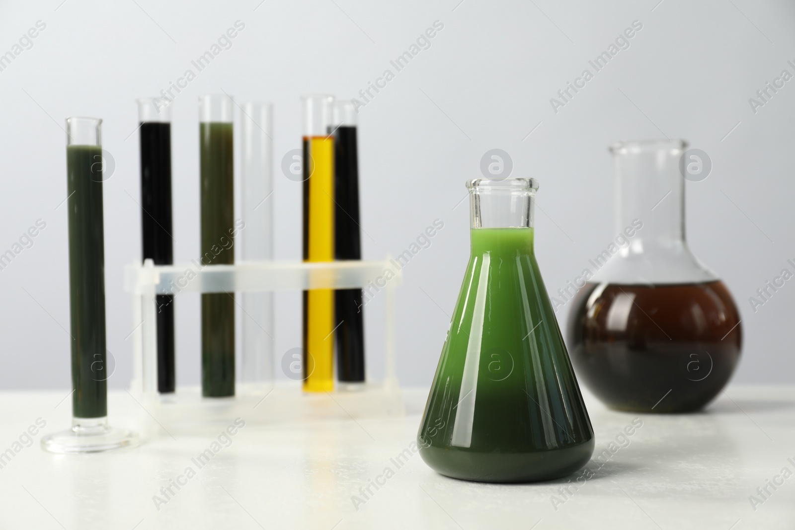 Photo of Laboratory glassware with different types of oil on white table