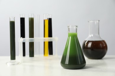 Laboratory glassware with different types of oil on white table