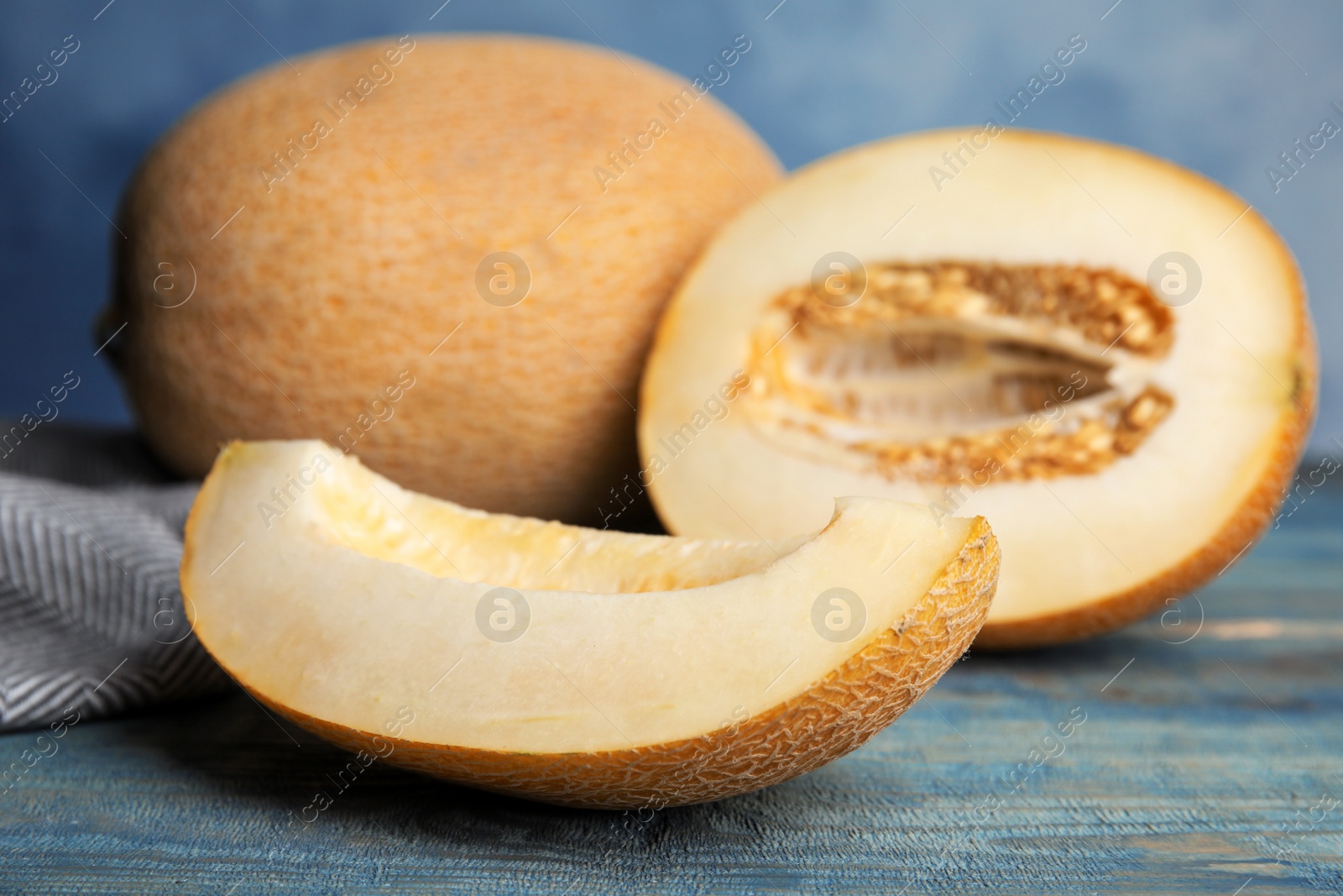 Photo of Tasty cut ripe melon on blue wooden table