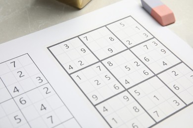 Photo of Sudoku and eraser on light table, closeup