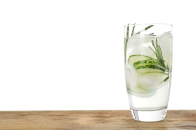 Glass of refreshing cucumber lemonade on wooden table against white background, space for text. Summer drink