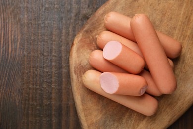 Photo of Whole and cut delicious boiled sausages on table, top view. Space for text