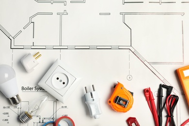 Flat lay composition with electrician's tools on house plan. Space for text