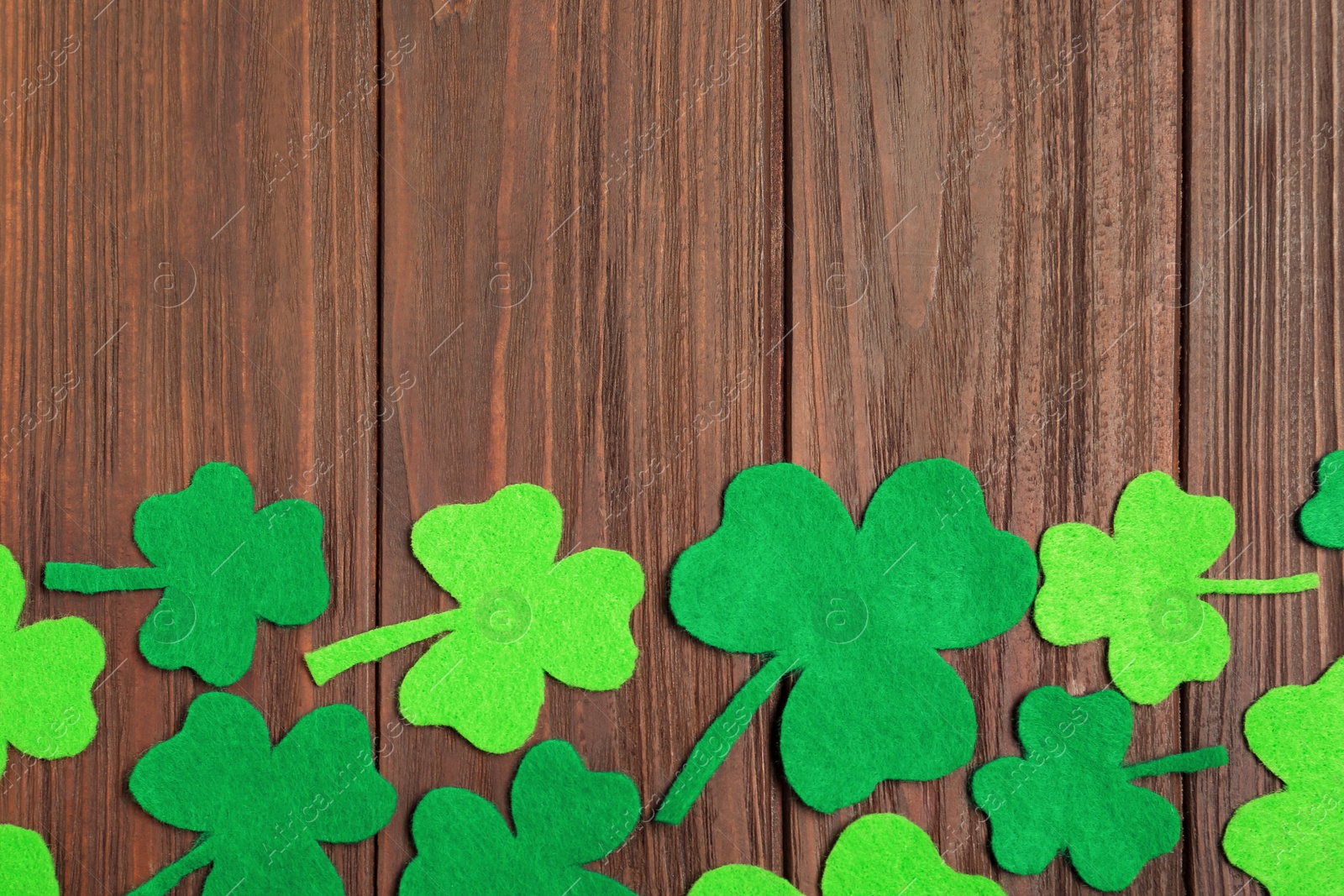 Photo of Flat lay composition with clover leaves on wooden background, space for text. St. Patrick's Day celebration