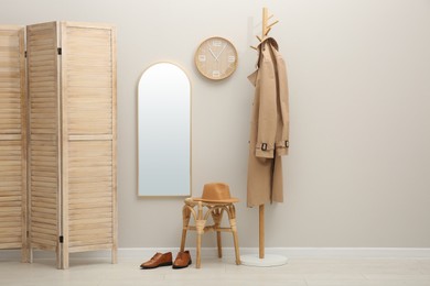 Photo of Hallway interior with wooden furniture near light wall. Stylish accessories