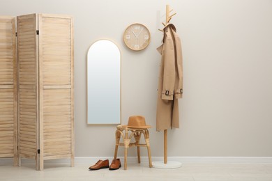 Hallway interior with wooden furniture near light wall. Stylish accessories