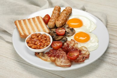 Plate with fried eggs, sausages, mushrooms, beans, bacon and toast on white wooden table, closeup. Traditional English breakfast