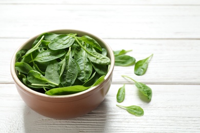 Photo of Fresh green healthy spinach on white wooden table. Space for text