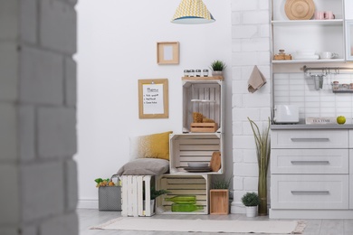 Photo of Modern kitchen interior with wooden crates as eco furniture