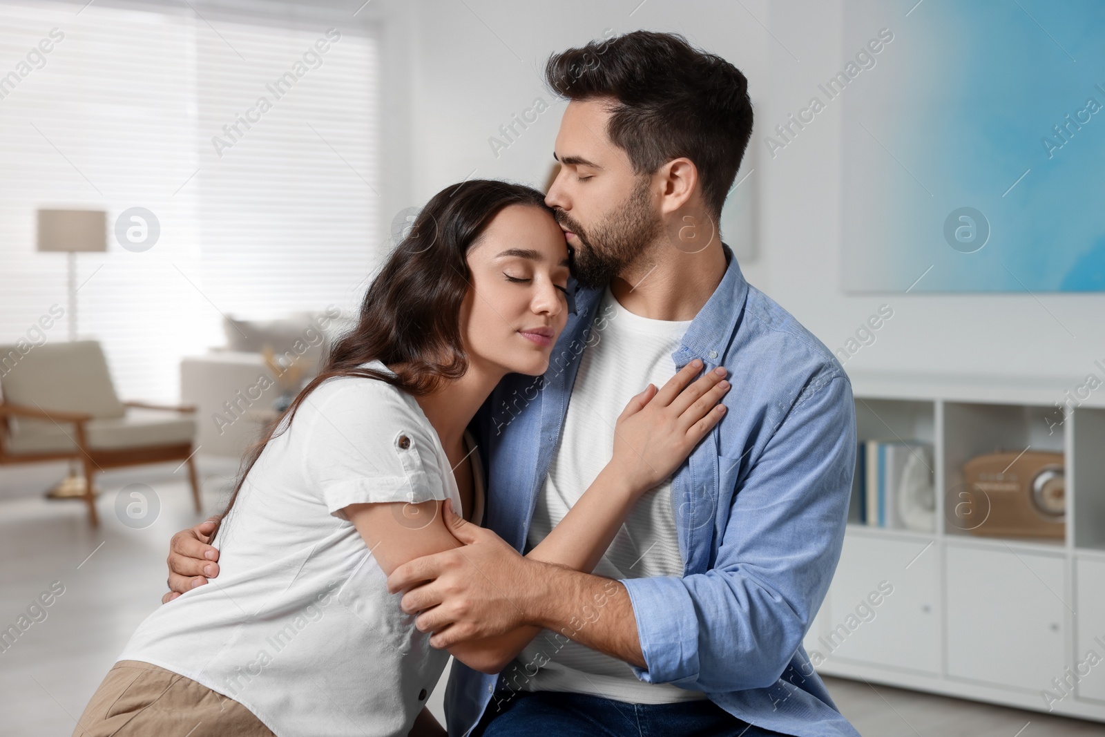 Photo of Cute couple. Man kissing his girlfriend at home