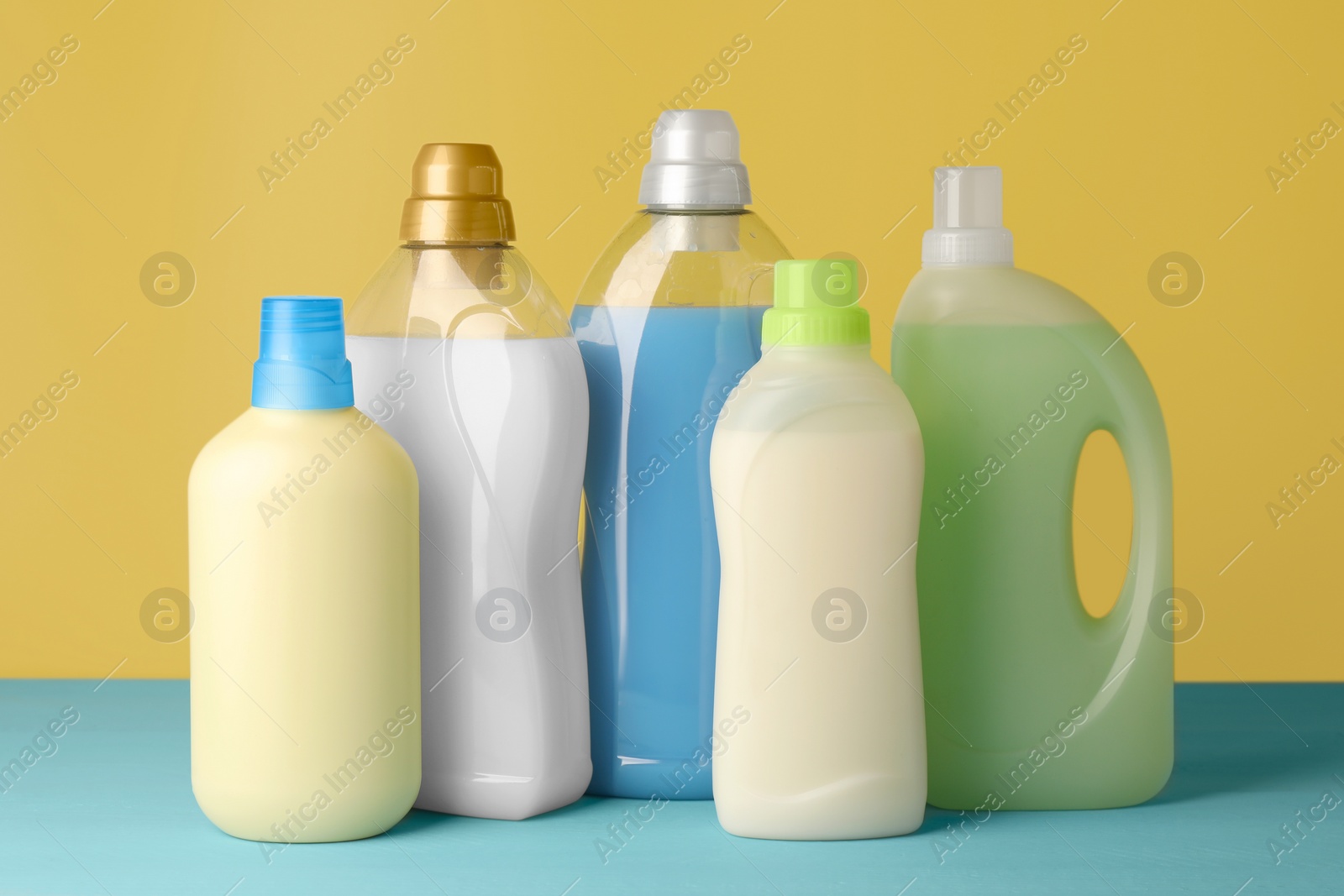 Photo of Bottles of fabric softener on light blue table