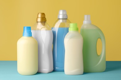 Photo of Bottles of fabric softener on light blue table