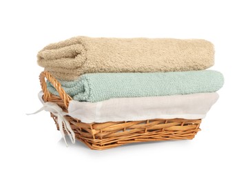 Wicker basket with folded bath towels isolated on white