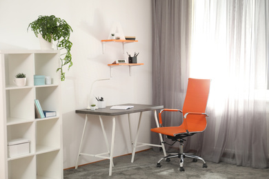 Photo of Stylish room interior with comfortable workplace near window