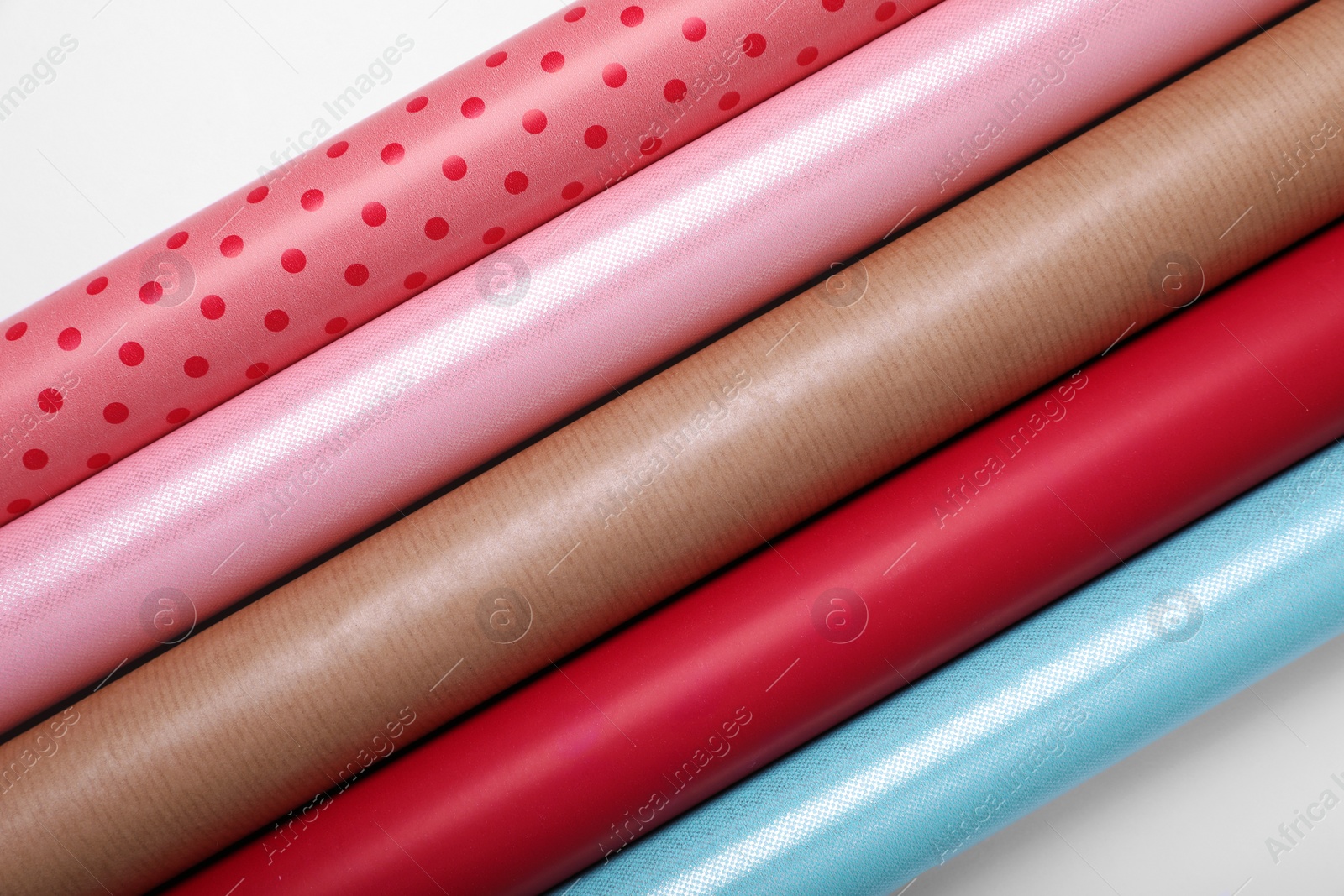 Photo of Rolls of different bright wrapping paper on white background, top view