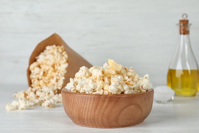 Photo of Wooden bowl with tasty popcorn on table