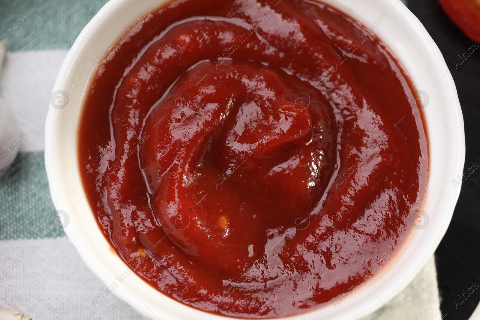 Photo of Organic ketchup in bowl on table, top view. Tomato sauce