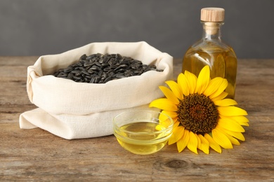 Photo of Sunflower, oil and seeds on wooden table